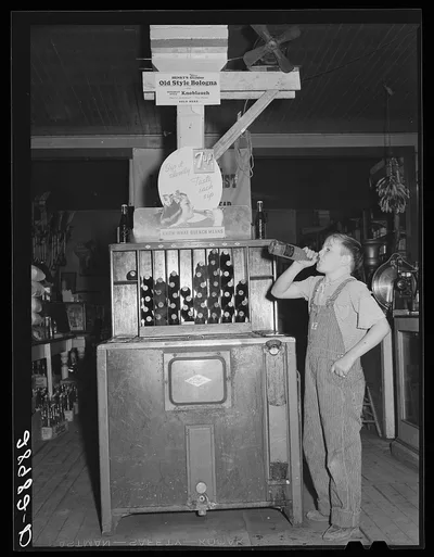 Farm boy at pop stand. General store. Lamoille, Iowa, 1939