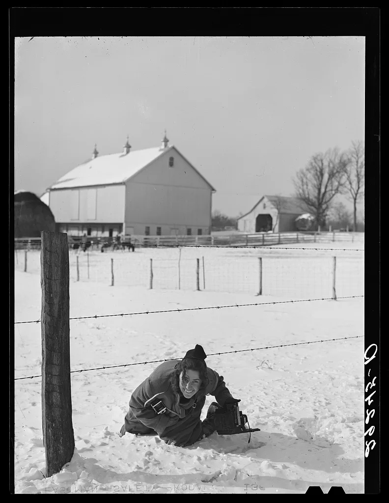 [Marion Post Wolcott crouched in the snow below a barbed wire fence…, Maryland, 1940