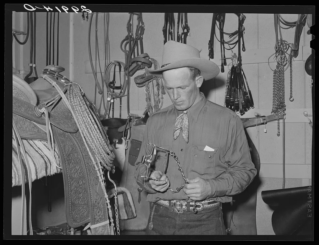 Cowhand examining bit. Capriola Saddlery, Elko, Nevada, 1940